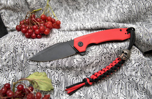 Folding knife beautiful design cutting black blade red handle viburnum natural product and lanyard paracord with scull bead - Photo, Image