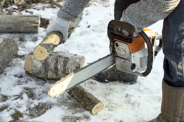 The process of cutting firewood with chainsaw  - Photo, Image
