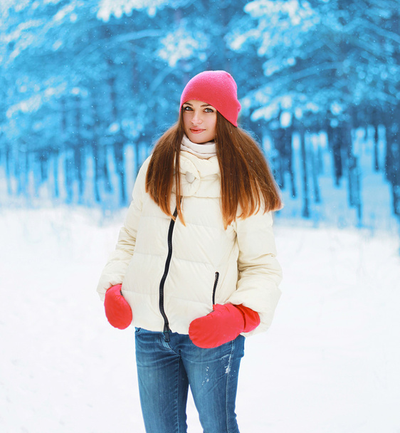Winter and people concept - pretty woman walking in snowy forest - Foto, Imagem