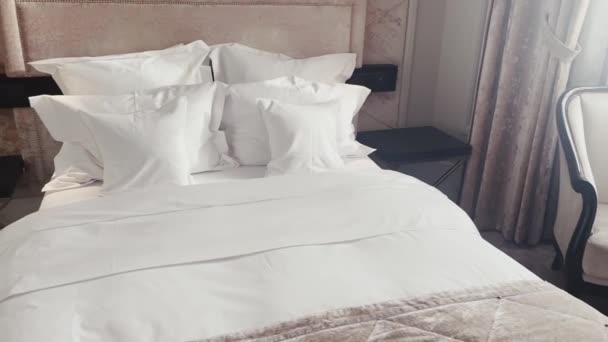 Wystrój wnętrz i wnętrz, łóżko z białą pościelą w luksusowej sypialni, pościel usługi pralnicze i szczegóły mebli. Wysokiej jakości materiał 4k - Materiał filmowy, wideo