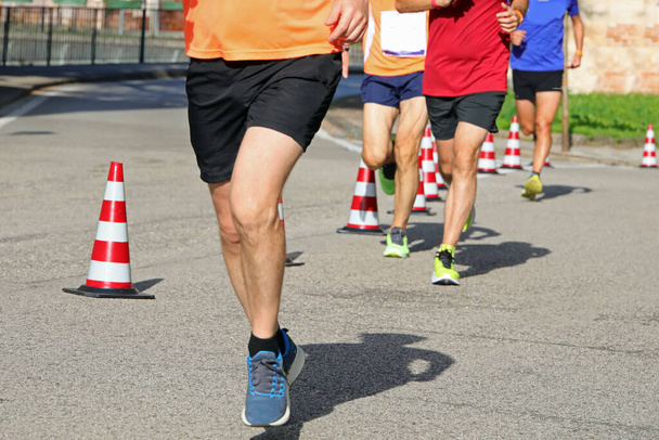 athletic runner with long muscular legs during the foot race in the city - Photo, Image
