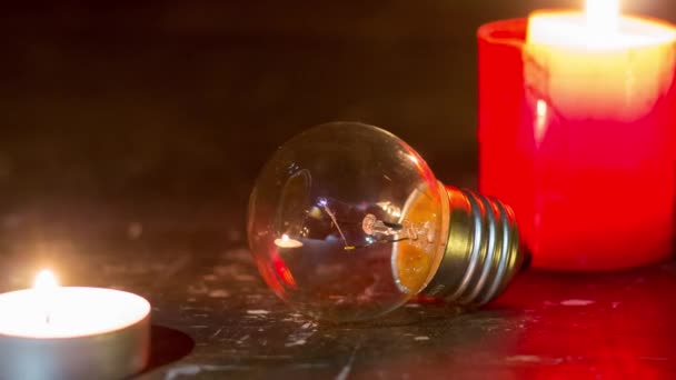 Glazen lamp tussen kaarsen. Blackout in Oekraïne als gevolg van oorlog - Video