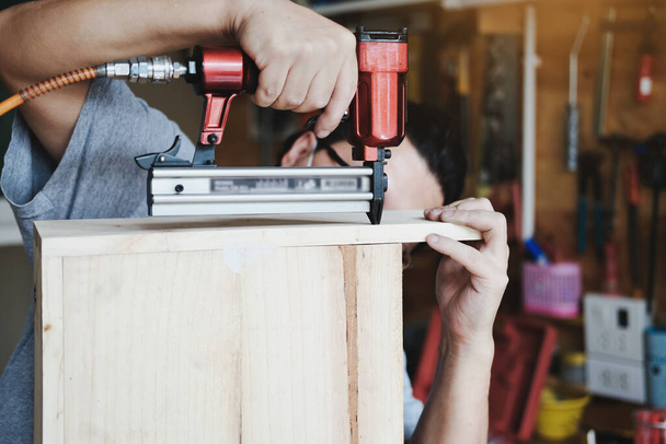 Podnikatel Dřevo drží Tacker sestavit kusy dřeva, jak si zákazník objednal - Fotografie, Obrázek