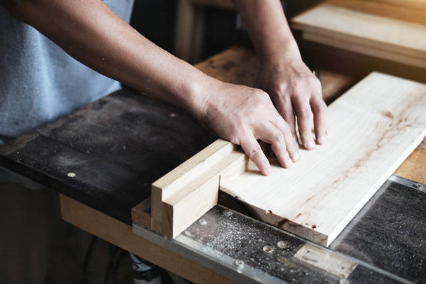 Houtbeoefenaars gebruiken zaagbladen om stukken hout te zagen om houten tafels te monteren en te bouwen voor hun klanten. - Foto, afbeelding