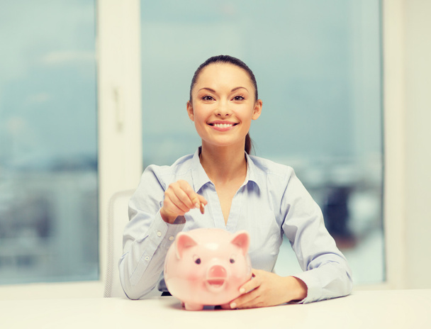 smiling woman with piggy bank and cash money - Foto, afbeelding