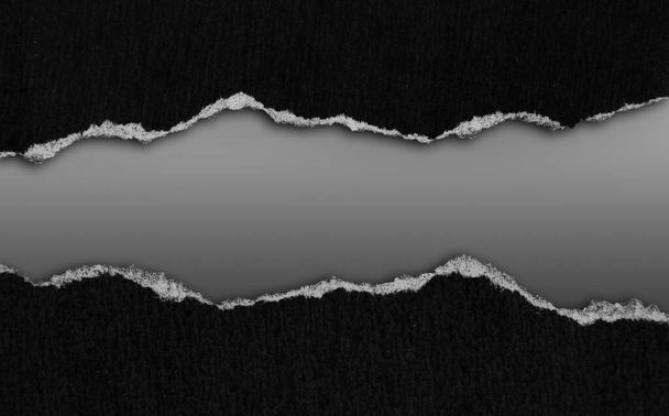 Papier noir déchiré sur fond gris - Photo, image