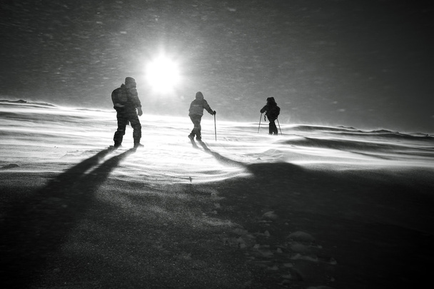 Wandelaars en sneeuwval in de winter bergen - Foto, afbeelding