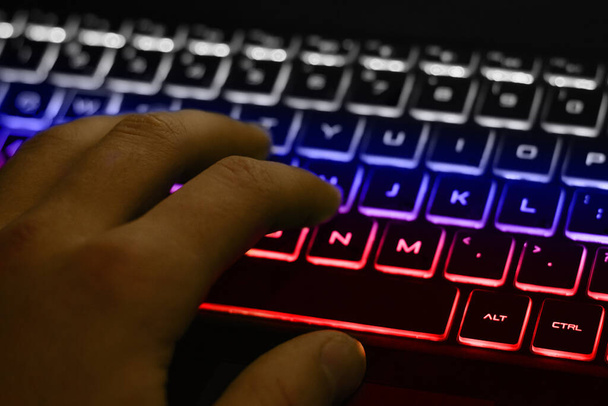 白、青、赤のバックライトでキーボードを入力する男の手。ロシアの旗の色のキーボードのバックライト - 写真・画像