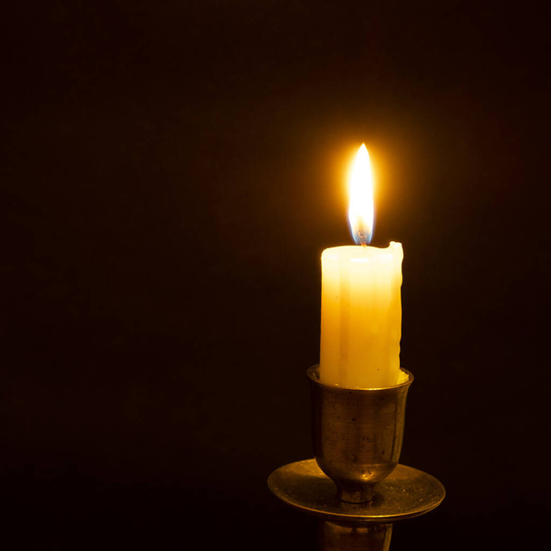 weiße brennende Kerze auf schwarzem Hintergrund - Foto, Bild