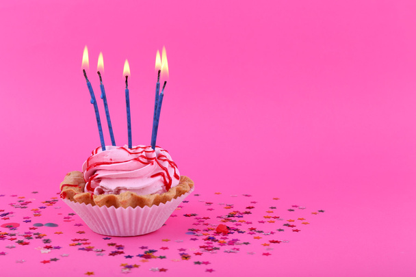 Birthday cup cake with candles and colorful stars on pink background - Fotoğraf, Görsel