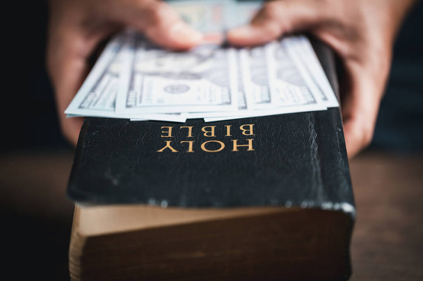 One tenth or tithe is basis on which Bible teaches us to give one tenth of first fruit to God. coins with Holy Bible. Biblical concept of Christian offering, generosity, and giving tithes in church. - Valokuva, kuva