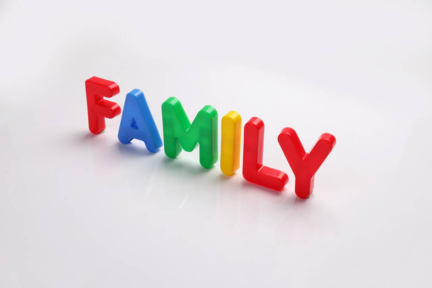 vermelho verde azul amarelo plástico brinquedo capital letra letra alfabeto família no fundo branco cópia texto espaço conceito  - Foto, Imagem