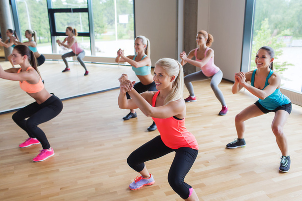 group of women making squats in gym - Foto, Bild