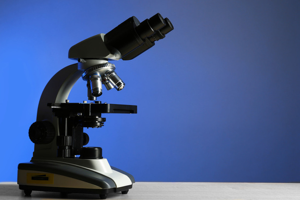 Microscope on table, on color background - Foto, Imagen