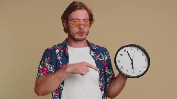 Це твій час. Портрет бородатого молодого чоловіка в сорочці, що показує час на годиннику, гаразд, великий палець вгору, схвалює, вказує палець на камеру. Дорослий хлопець в приміщенні студійний знімок ізольований один на бежевому фоні
 - Кадри, відео