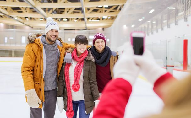 happy friends taking photo on skating rink - Photo, Image