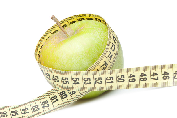 Closeup of a green apple with a measuring tape. Isolated on whit - Photo, Image
