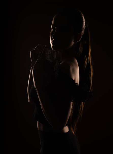 Close up of a sihouette of a beautiful girl posing in a studio - Foto, Bild