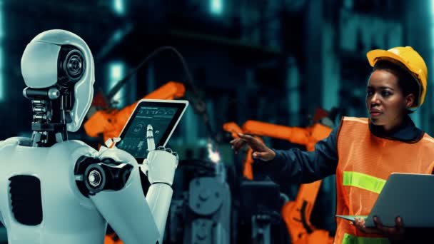 Cybernated industry robot and human worker working together in future factory . Concept of artificial intelligence for industrial revolution and automation manufacturing process . - Materiaali, video