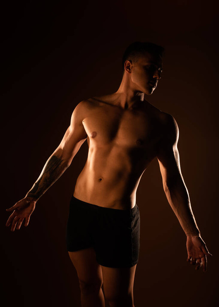 Przystojny mężczyzna z mięśniami pozujący w studio - Zdjęcie, obraz