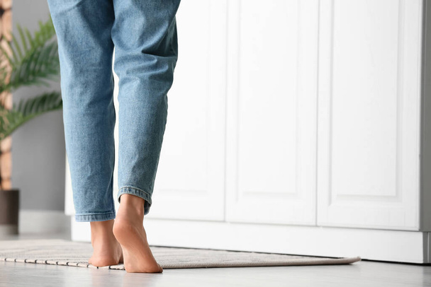 Female barefoot legs on carpet in kitchen - Fotografie, Obrázek