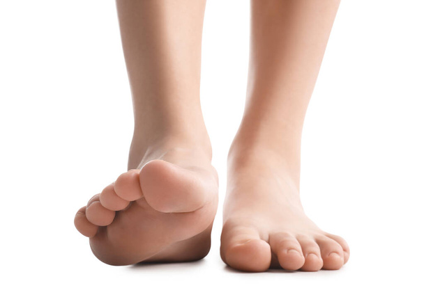 Vrouwelijke blote voeten op witte achtergrond - Foto, afbeelding