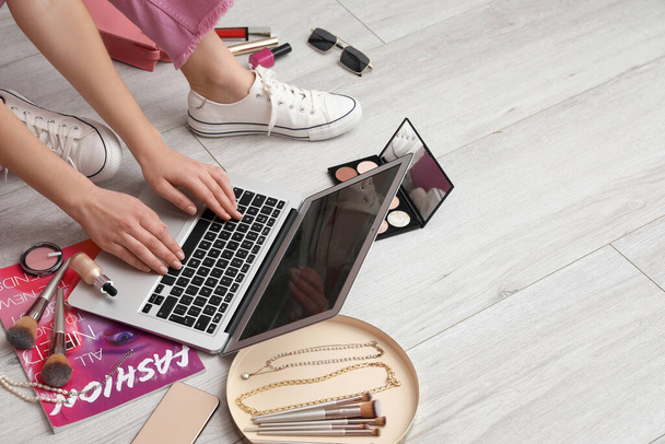 Blogger de belleza femenina con portátil, cosméticos decorativos y accesorios en suelo de madera claro - Foto, imagen