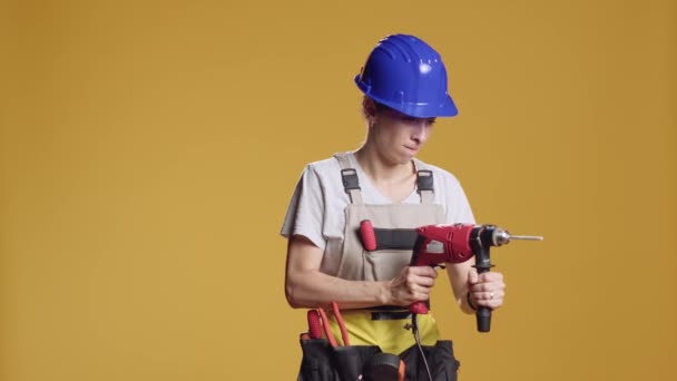 Powerful handywoman using power drill nail gun to screw nails, working with electric drilling gun machine on construction repair. Rebuilding architecture on engineering project in studio. - Footage, Video