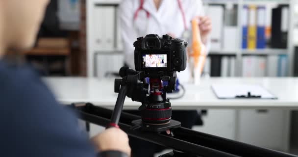 Videografo gira video educativi sulla medicina. Concetto di educazione medica a distanza - Filmati, video