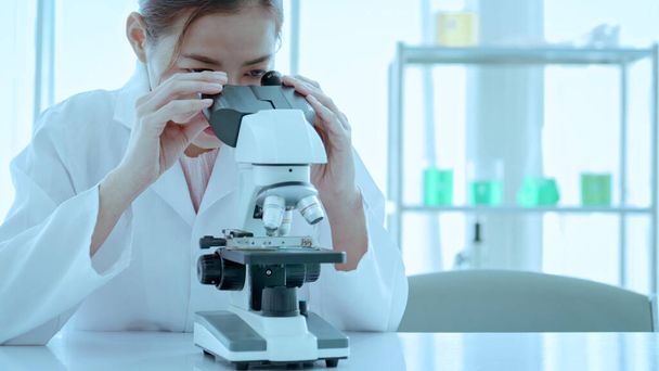 A közeli tudósok mikroszkópot használnak a laborban. Biotechnológiai kutató tudós dolgozó megjelenés mikroszkóp az orvosi fejlesztési laboratóriumban a vakcina fejlesztése - Fotó, kép