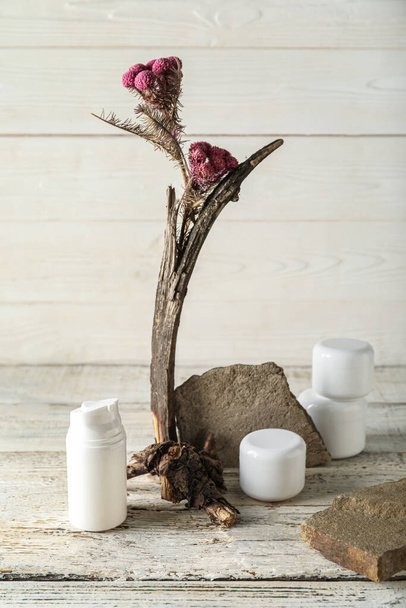 Productos cosméticos con ikebana sobre fondo blanco de madera - Foto, Imagen