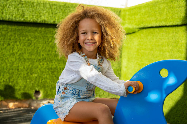 Pretty child girl with curly hair playing, Playground outdoors. - Foto, Imagen