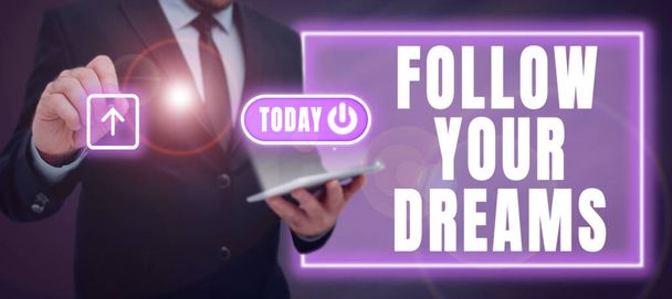 Podpis Conceptual Follow Your Dreams, Business showcase motywacyjne i inspirujące wyrażenie, aby realizować swoje pragnienie serca Biznesmen w garniturze z Pad And Pen Wgrywanie Ważne informacje. - Zdjęcie, obraz