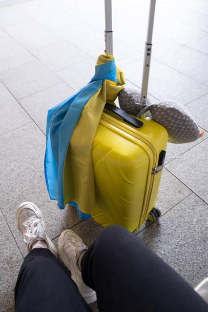 yellow bag with ukrainian flag traveler body part - Valokuva, kuva