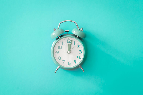 Blue alarm clock on blue background isolated, flat lay, time management concept. - Photo, image