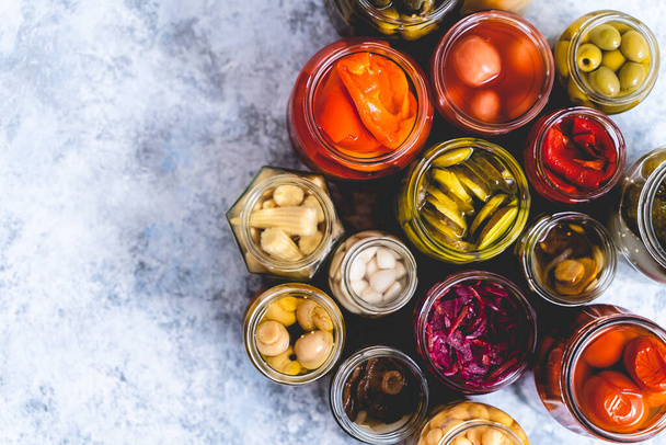 Cucumber, pepper, tomatoes, mushrooms pickling and canning into glass jars. Ingredients for vegetables preserving. Top view. Flat lay. - Fotó, kép