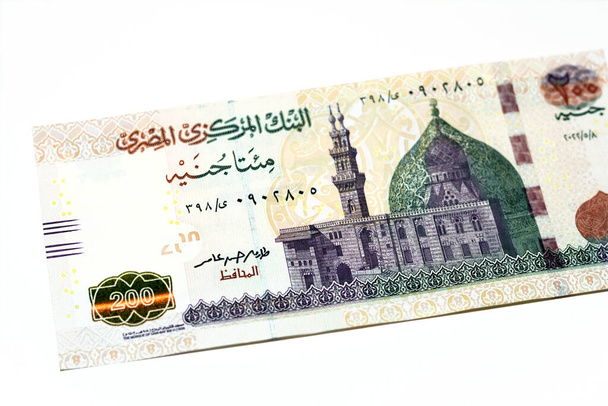 Obverse side of 200 LE EGP two hundred Egyptian pounds cash money banknote series 2022 features the mosque of Qani-Bay in Cairo, Egypt, selective focus of Egyptian money isolated on white background - Фото, зображення
