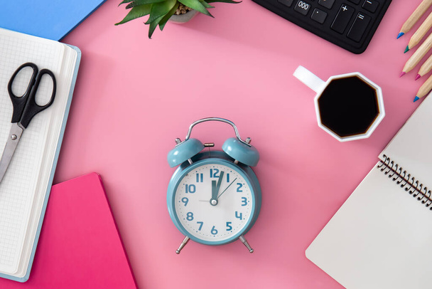 文房具、目覚まし時計、ピンクの背景にコーヒーカップ付きフラットレイ、職場のコンセプト. - 写真・画像