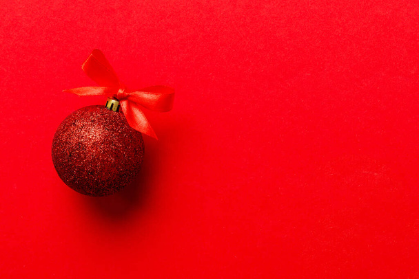 Christmas ball on colored background. decoration bauble with ribbon bow with copy space. - Foto, afbeelding