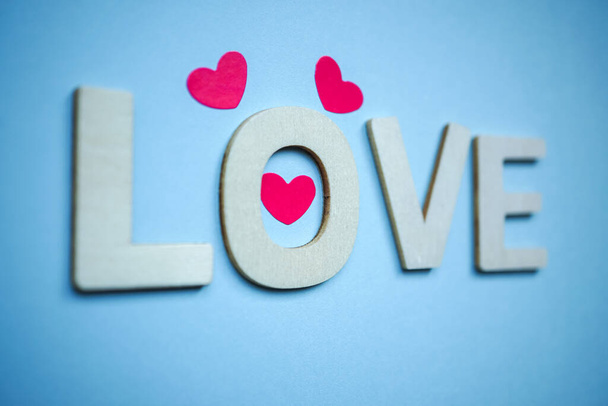 miłość drewniane litery i kształty serca na niebieskim tle na Walentynki  - Zdjęcie, obraz
