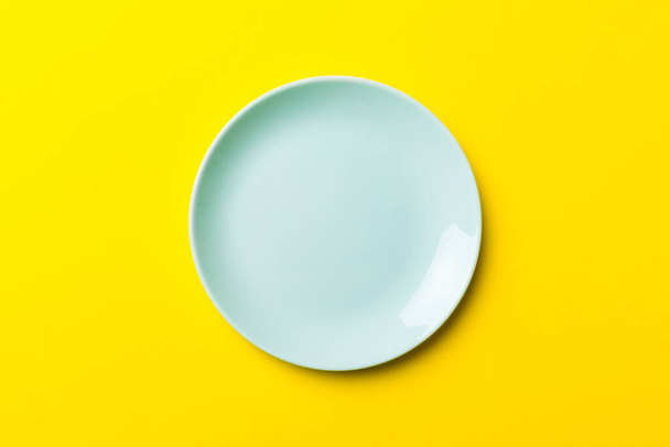 Widok z góry izolowane kolorowe tło pusty okrągły niebieski talerz do żywności. Puste naczynie z miejscem na projekt. - Zdjęcie, obraz