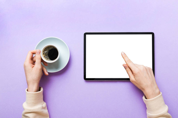 Close up image woman hands holding digital tablet with blank copy space screen for your text message or promotional content om table with cup of coffee. hands of a woman holding blank tablet device. - Photo, Image