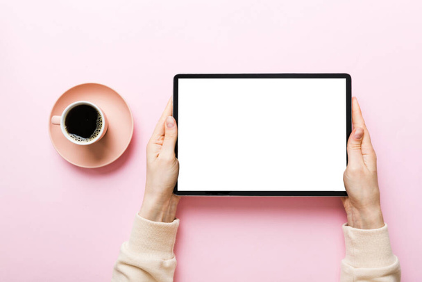 Close up image woman hands holding digital tablet with blank copy space screen for your text message or promotional content om table with cup of coffee. hands of a woman holding blank tablet device. - Photo, Image