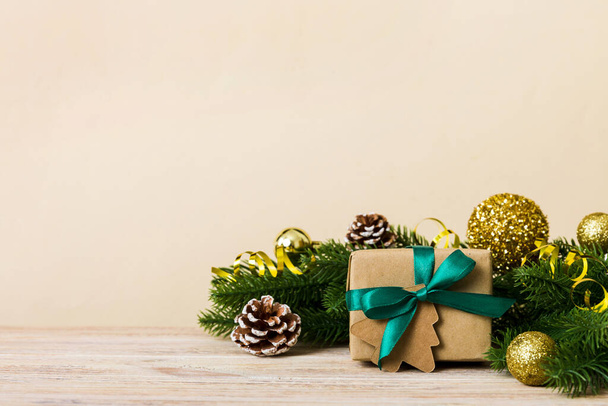 New Year Christmas mood, gift box, branches of a christmas tree, New Year decorations on a colored background. - Foto, Imagem