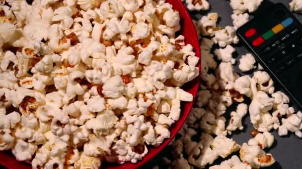 Ciotola di popcorn con telecomando 4k dolly medium shot fuoco selettivo - Filmati, video