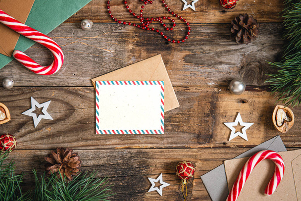 Carte postale vierge, enveloppe et détails de décoration de Noël sur fond en bois, pose plate. - Photo, image