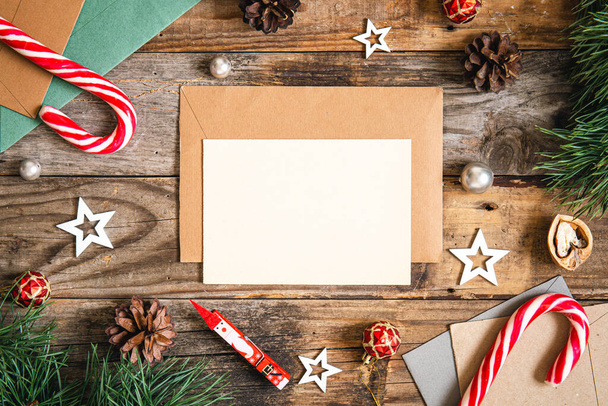 Пустая бумага, конверт и детали рождественского декора на деревянном фоне, плоский уголок. - Фото, изображение