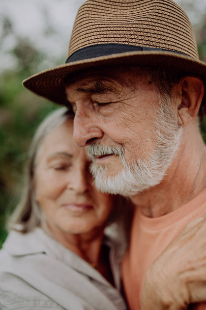 Portrait of senior couple in love, standing outdoor in the nature. - Фото, изображение