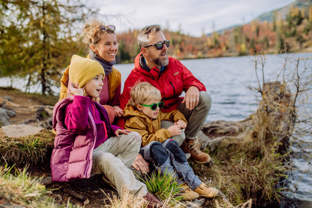 Happy young family with little children, resting near a lake in mountains. - Foto, Imagen