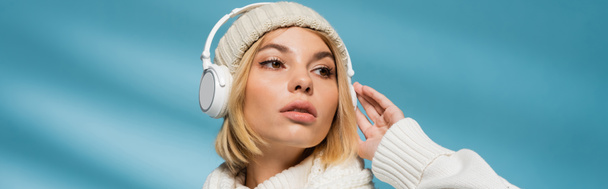 tyylikäs nuori nainen talvella asu ja langattomat kuulokkeet kuuntelee musiikkia sininen, banneri - Valokuva, kuva